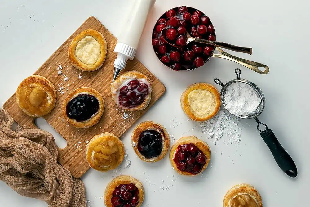 Puff Pastry Cream Cheese Danish(146)-w Overhead photograph of the Puff Pastry Cream Cheese Danish being decorated with frosting.