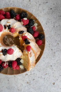 wine cake on a serving platter, decorated with berries.
