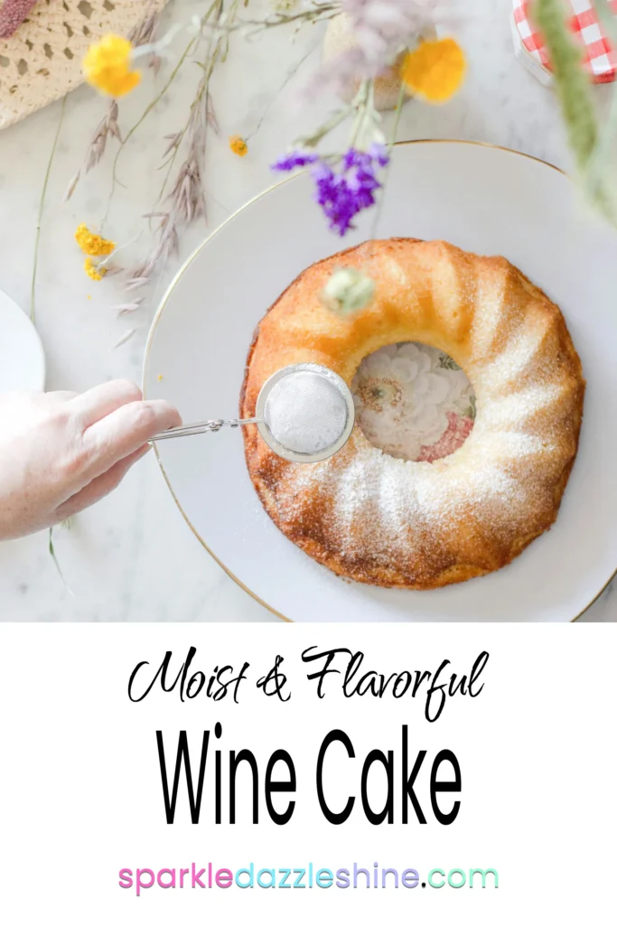 bundt wine cake in a white serving tray, setting on a white and grey granite countertop surrounded with spring flowers.
