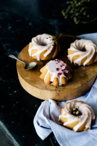 three mini frosted bundt cakes on wooden tray 