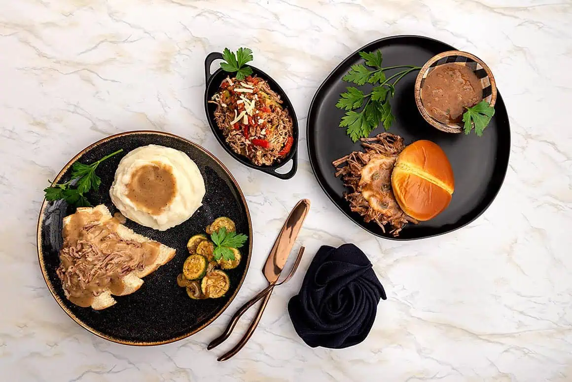 Setting on a marble table are two plates containing Delicious Gravy and more gravy.