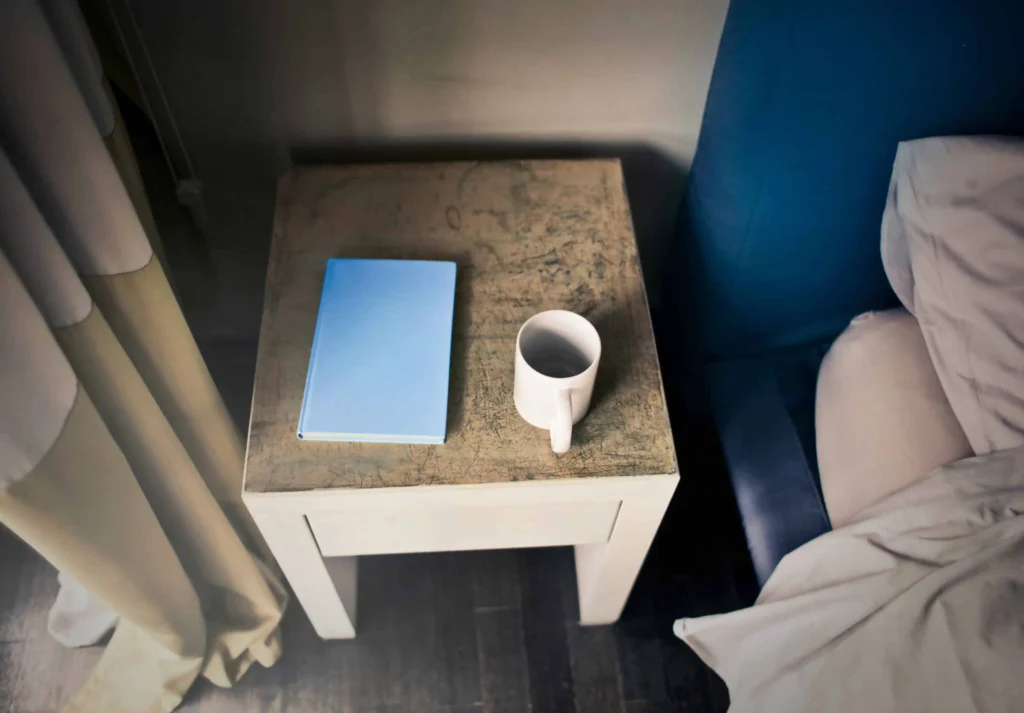 Journaling Techniques for a better you A simple square bedside table with a coffee cup and journal