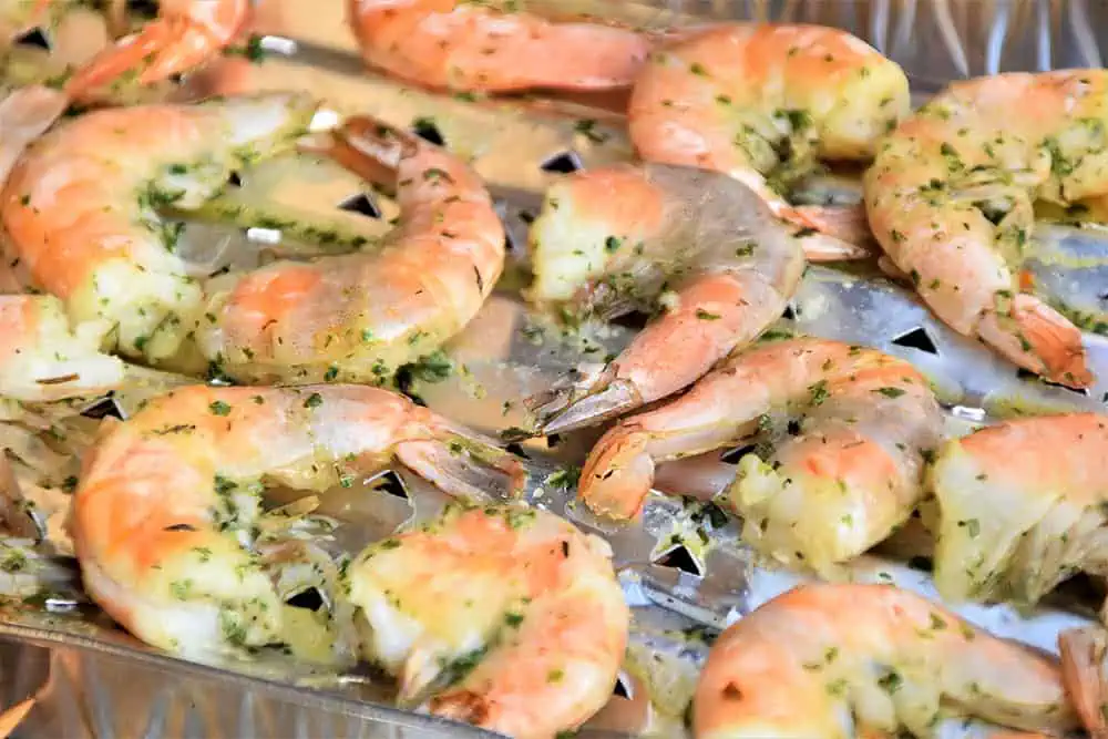 Shrimp Scamp and Veggies Over Pasta. Cooked shrimp on a broiler plate.