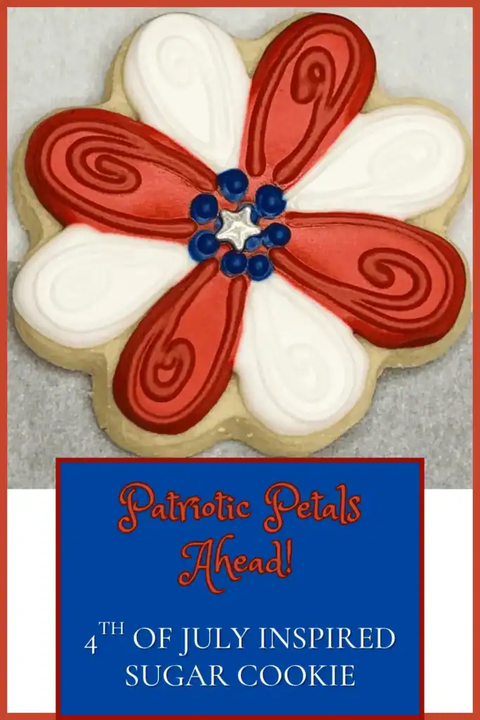 Patriotic flower-shaped sugar cookie decorated in red and white icing with a blue sprinkle center, labeled “Patriotic Petals Ahead – 4th of July Inspired Sugar Cookie.”