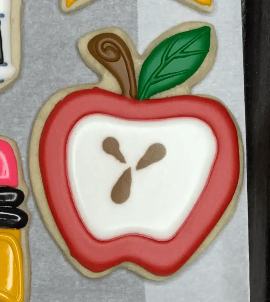 half apple sugar cookie decorated with royal icing