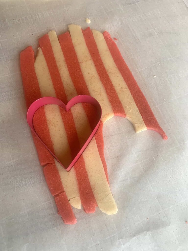 Red and natural colored cookie dough laid out in a alternating stripe pattern.