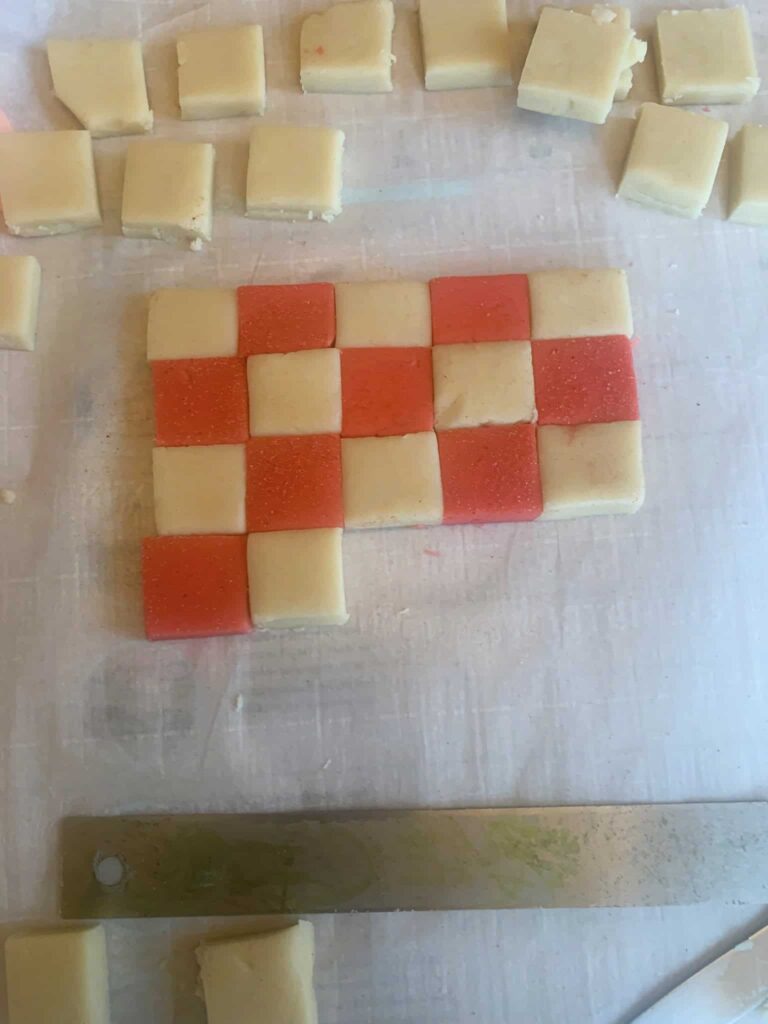 Red and natural colored cookie dough laid out in a checked pattern.