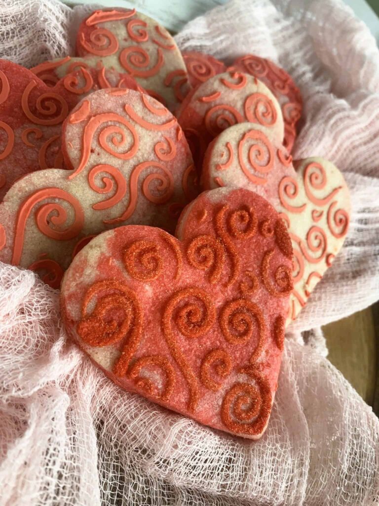 Heart shaped sugar cookies with marbled colored dough and swirl stencil pattern.