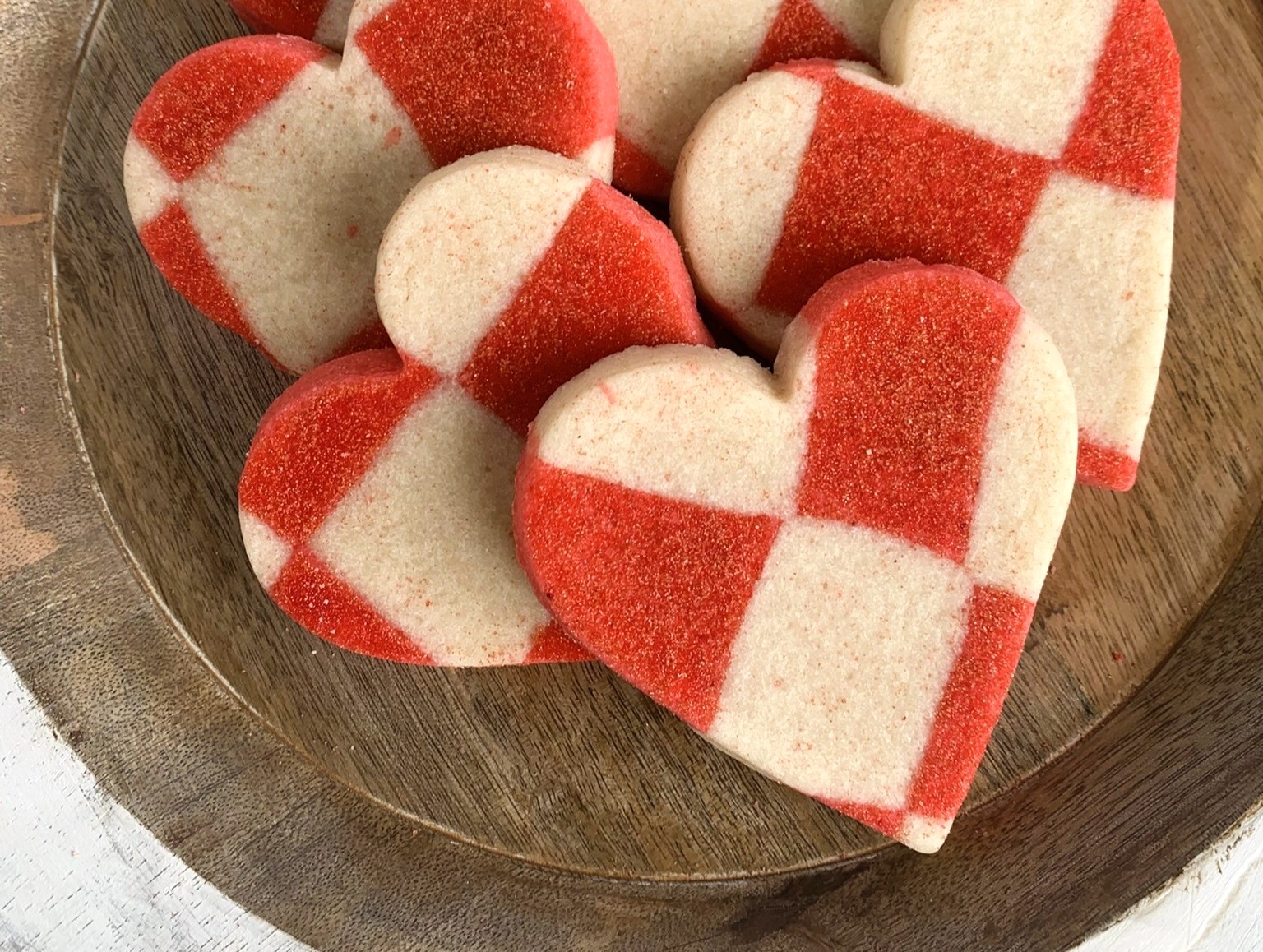 Playful Valentine Sugar Cookies. Heart shaped sugar cookies on a wood serving tray with a harlequin checked dough pattern.