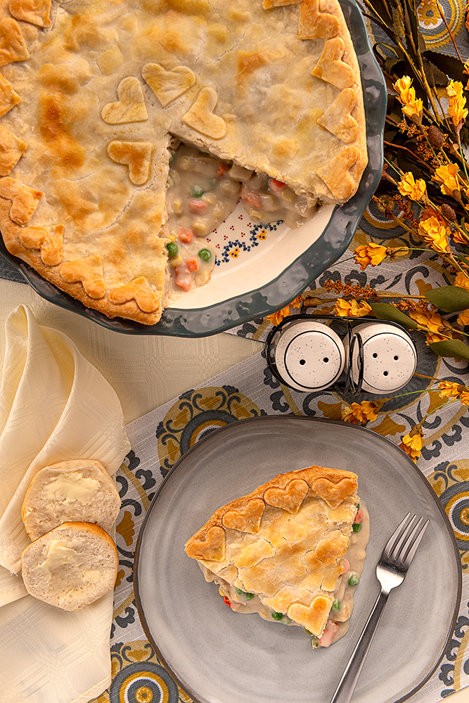 Classic Chicken Pot Pie - close up image of a chicken pot pie and a plate with a slice of that chicken pot pie.
