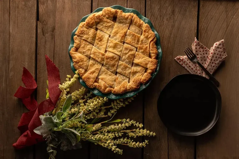 Best Flaky Pie Dough Recipe. Lattice pie crust over an apple pie, setting next to the pie is a dessert plate, fork and napkin.