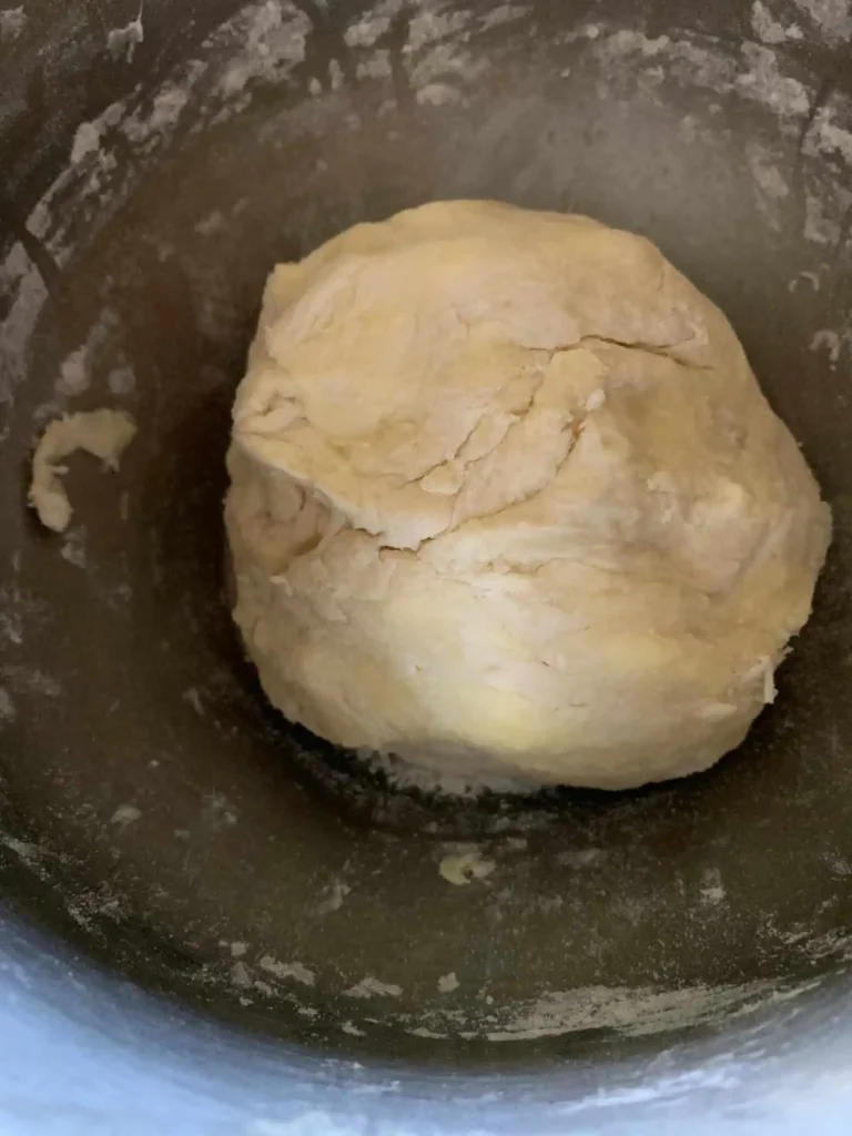 Ball of best flaky pie dough in a mixing bowl.